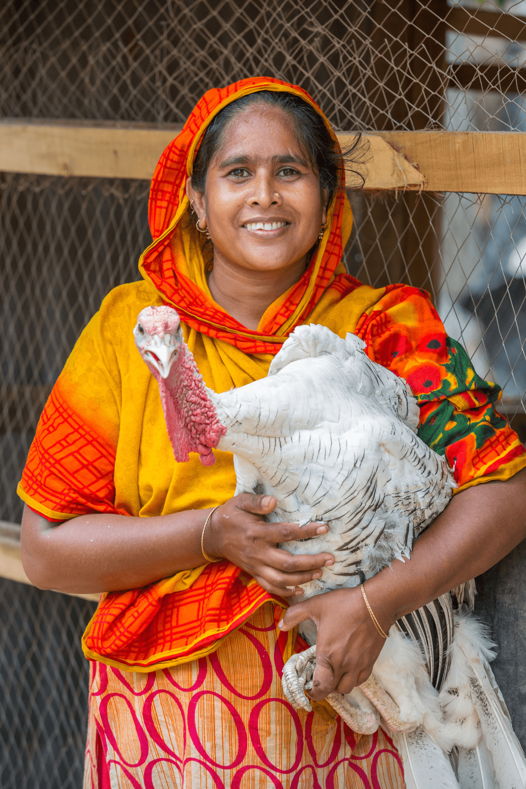 Farmer holding white turkey poultry in a well-maintained farm